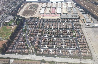 Vista aérea de hileras de viviendas en serie en el sur de California, el tipo de distrito cuyo valor mediano y recuentos por manzana forman el conjunto de datos de vivienda.
